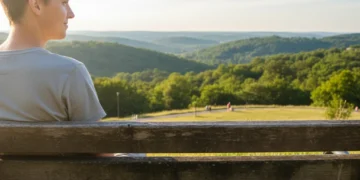Person on bench unplugging from phone in nature