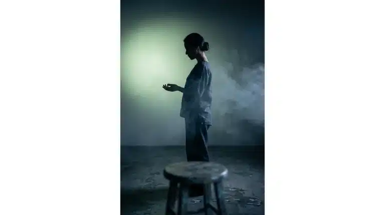 A person in a contemplative pose, silhouetted against a soft green light, representing holistic well-being and preventative care.